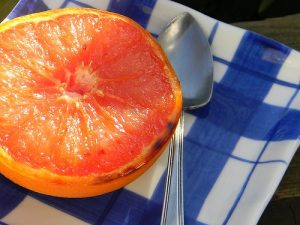 A broiled grapefruit on a plaid plate
