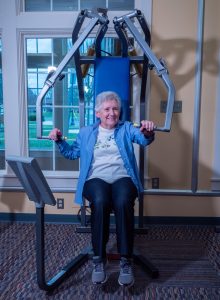 Senior adult woman exercising at the chest press machine.