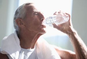 Older male drinking from water bottle