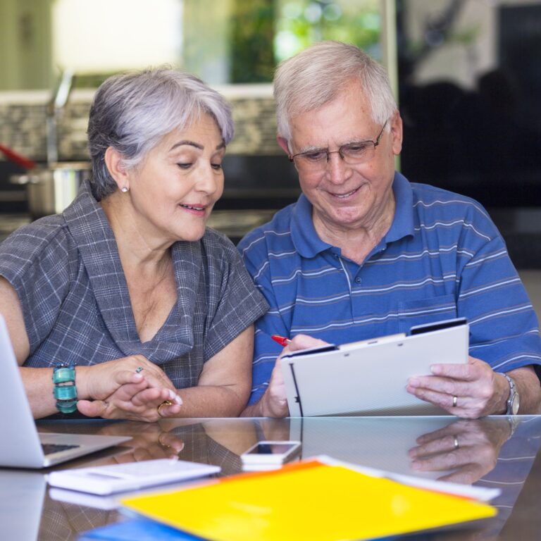 Photo of senior couple reviewing paperwork to understand the cost of long-term care