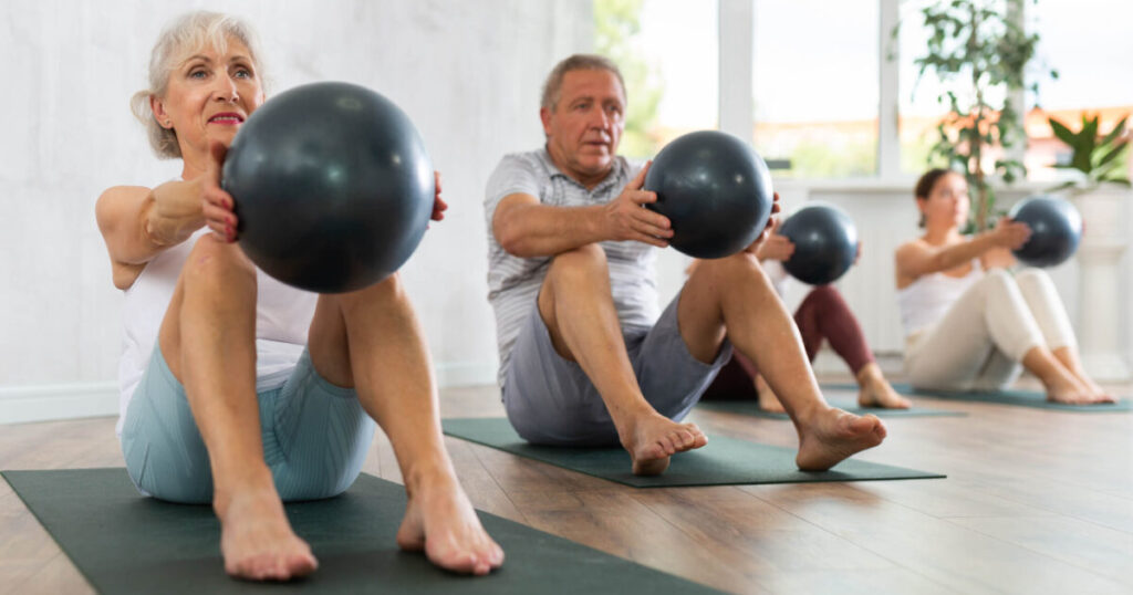 Group working with exercise ball One Is Not Like the Other Retirement Communities