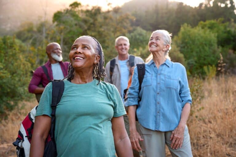 moving group of active smiling seniors take a hike