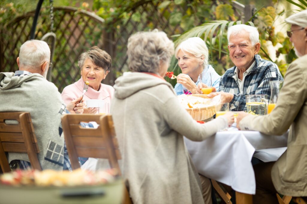 Elderly friends at the table,having fun during summer garden party