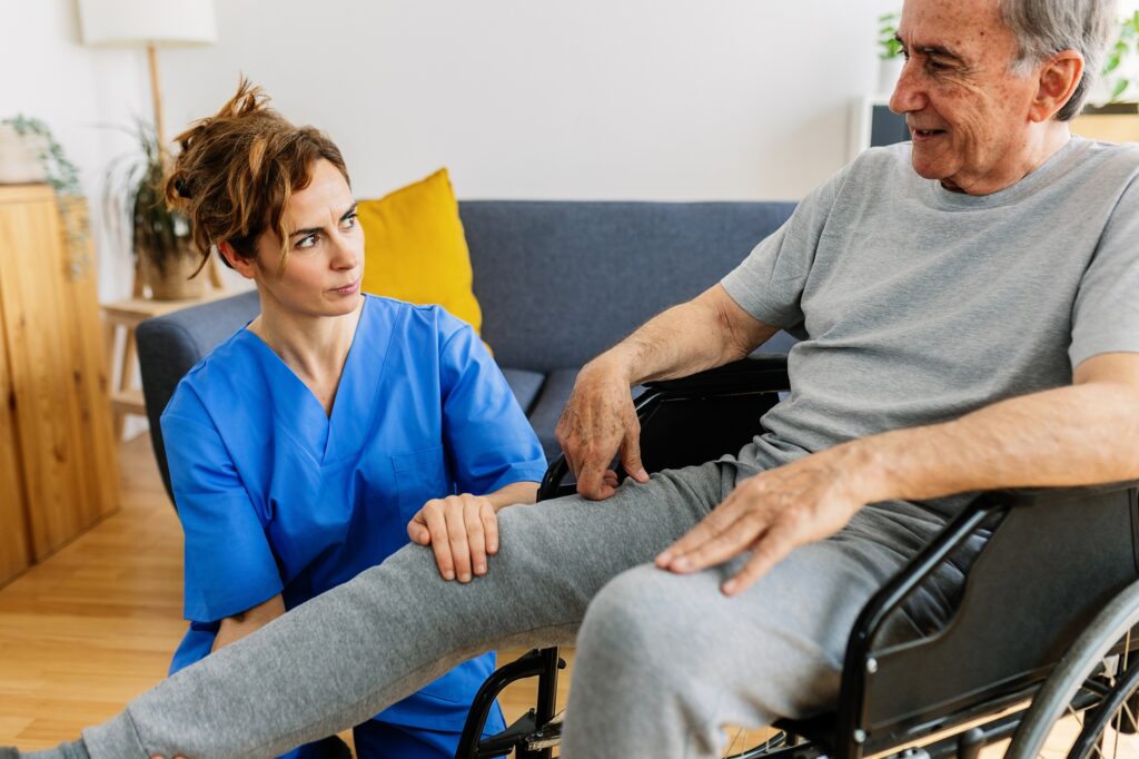 Physiotherapist doing rehabilitation to an older patient after leg surgery