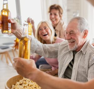Senior friends watching movie indoors, party, social gathering and having fun concept.