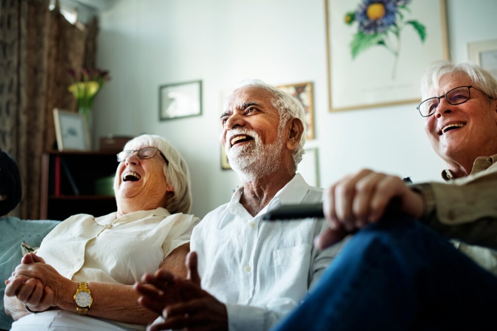 Senior people watching television together