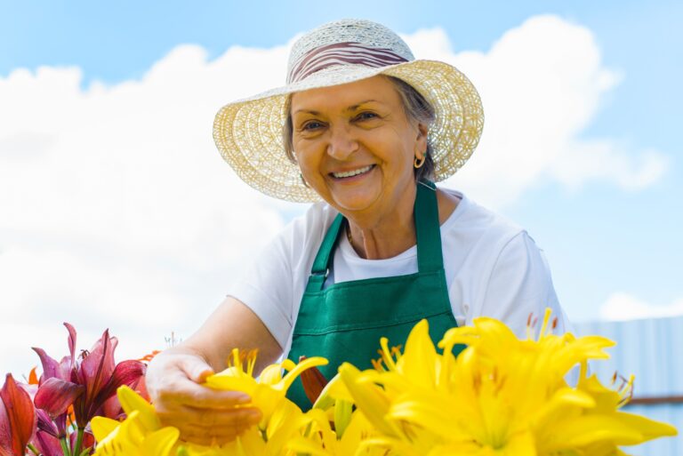 Elderly woman working in garden and looking at camera, gardening hobby
