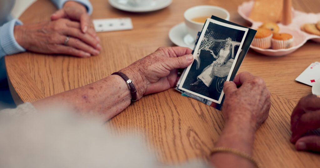 Hands, picture and senior people in home with memory, remember or reminiscing in conversation. Talk