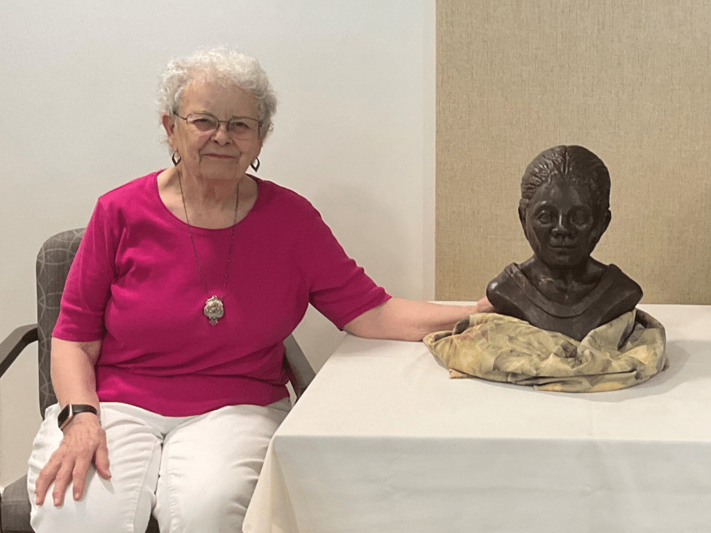 Martha Wiseman with bust of Mae E. Prince